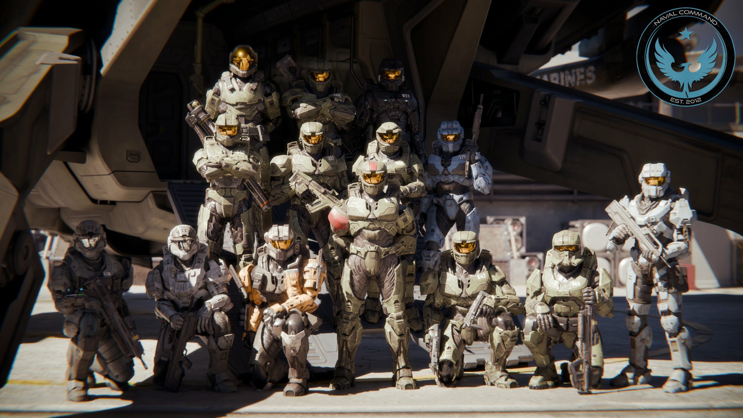 A group of Spartans poses for a wartime photo on the tarmac beside a waiting Pelican.