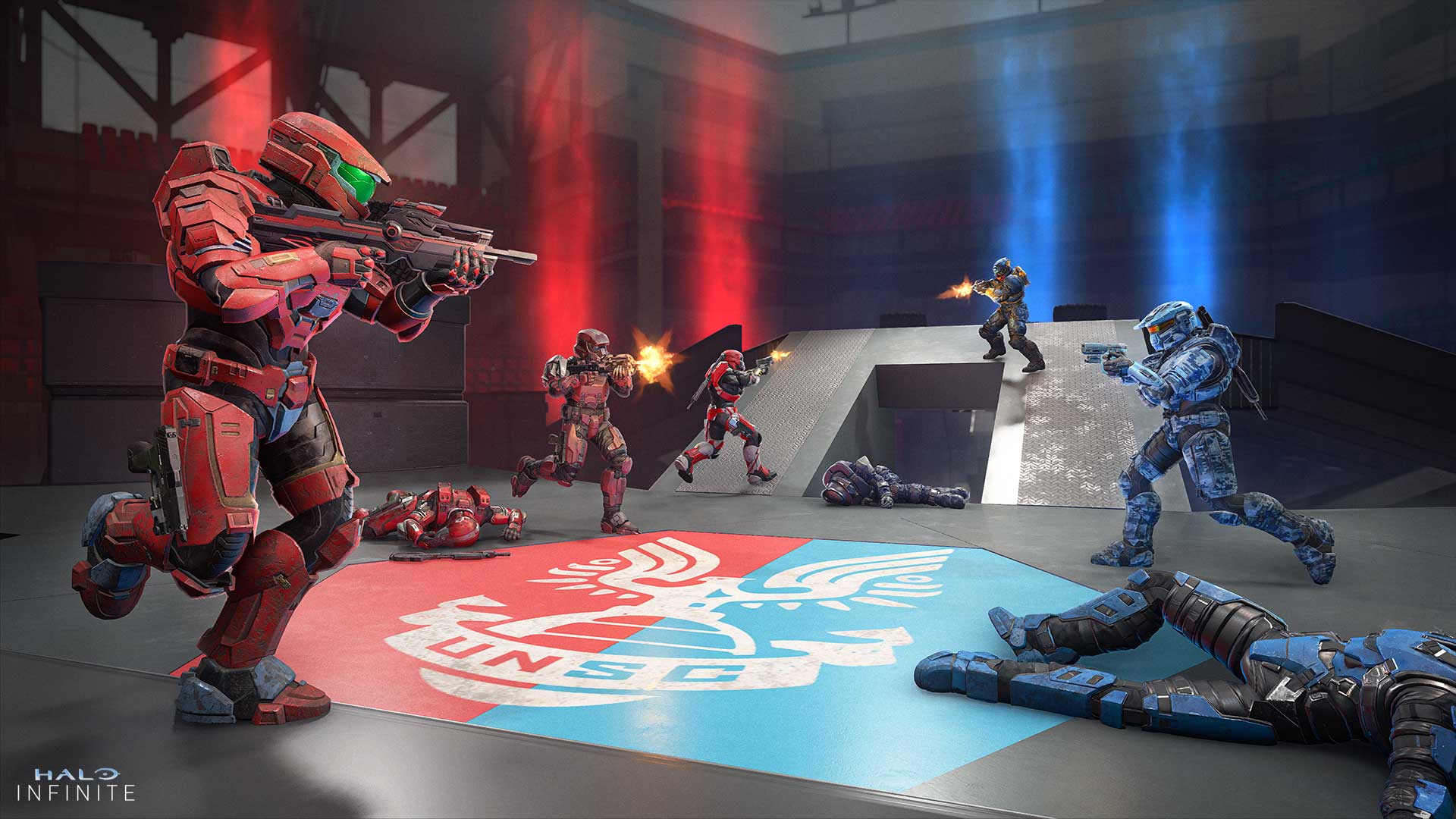 Extermination mode. Red and Blue Spartan teams race toward each other in fierce combat. Similarly colored light emanates behind each team respectively. On the floor, a UNSC logo is emblazoned on a colored field that is evenly divided between red and blue halves.
