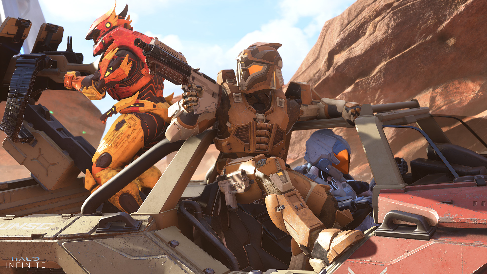 A Spartan in Artificer armor aims their weapon from the passenger’s seat of a Warthog while allies drive and operate a rear-mounted turret.