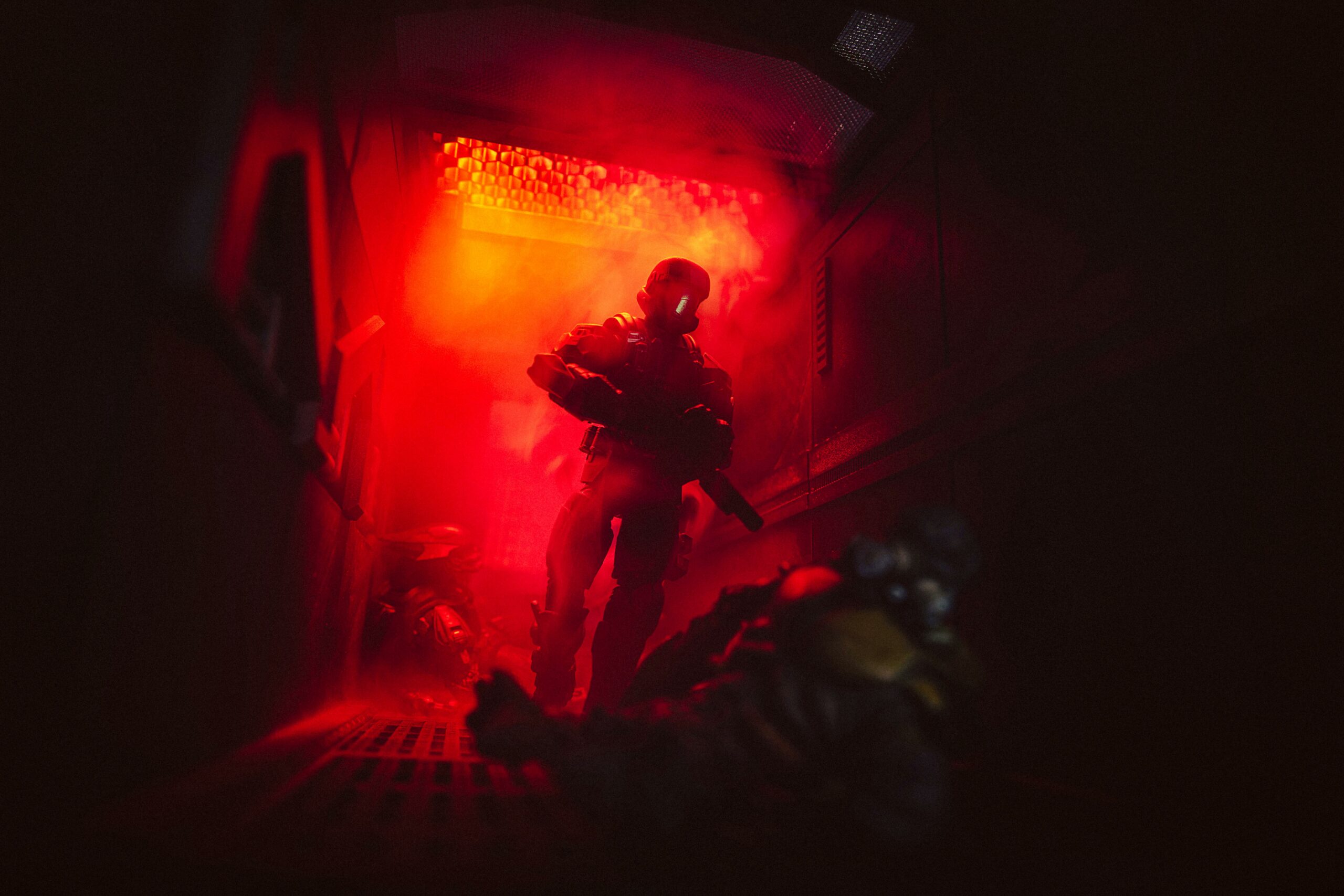 Toy photography by Firespray. An ODST stalks through a foggy, red-lit corridor past fallen Grunts.
