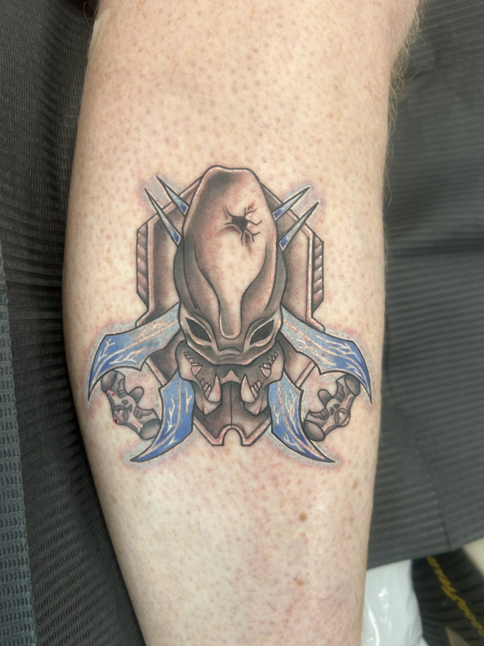 A tattoo featuring Halo's iconic Legendary difficulty emblem.