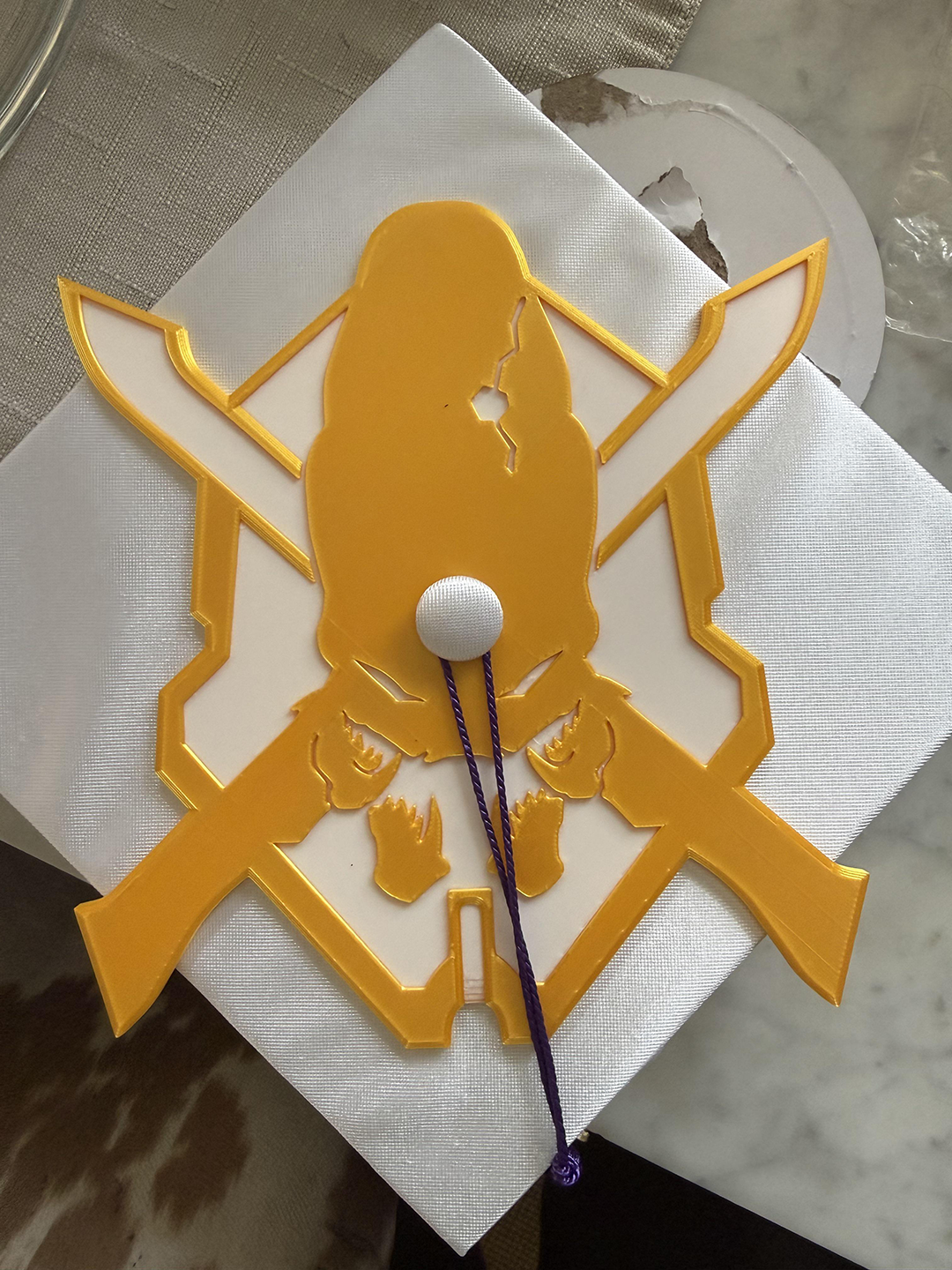 A graduation cap with the Legendary skull on the top of it.