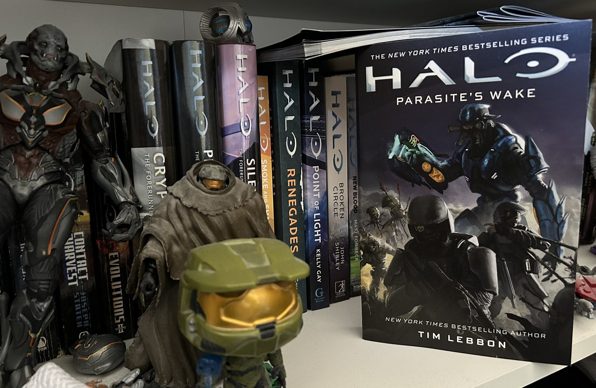 Photo of Halo: Parasite's Wake on a bookshelf among other Halo novels and toys